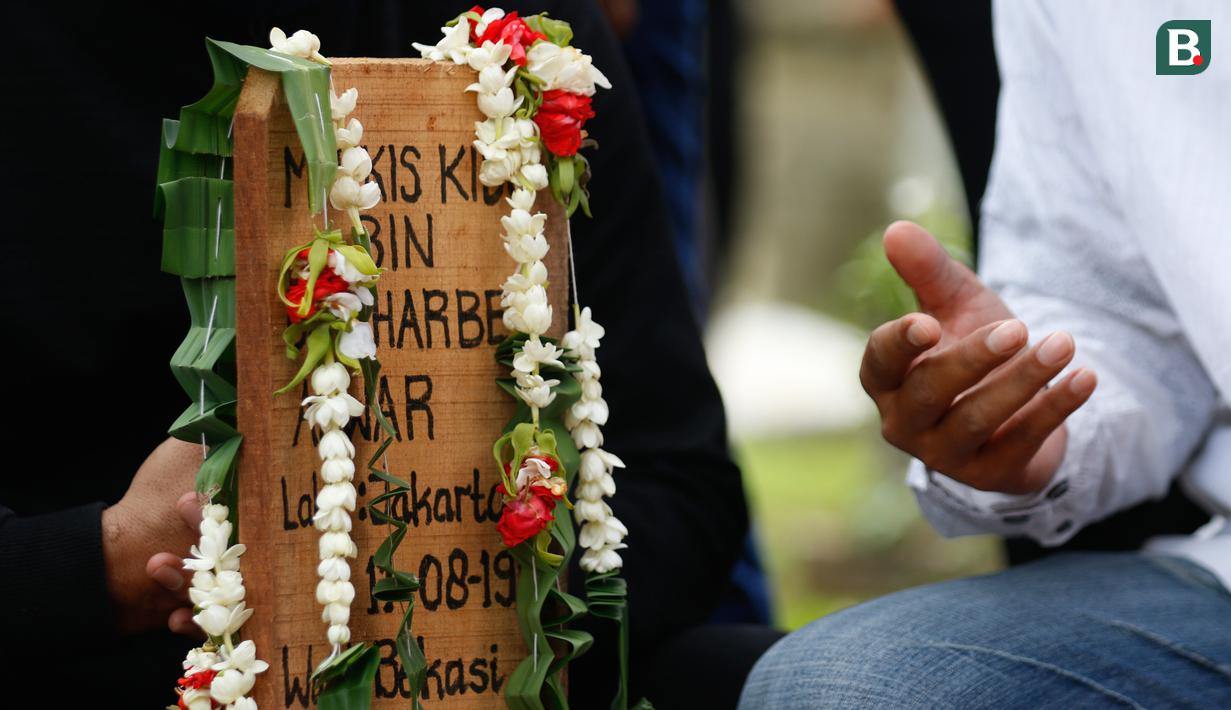 Kerabat dari legenda bulutangkis Indonesia, Markis Kido memberikan doa didepan pusara di TPU Kebon Nanas, Cipinang, Jakarta, Selasa (15/6/2021). (Foto: Bola.com/Bagaskara Lazuardi)