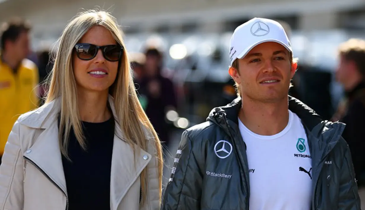 Pembalap F1, Nico Rosberg berjalan dengan Wanita canti asal Jerman, Vivian Sibold sebelum dimulainya balapan di Sirkuit The Americas pada pada 2 November 2014, Amerika Serikat. (AFP/ Clive Mason)