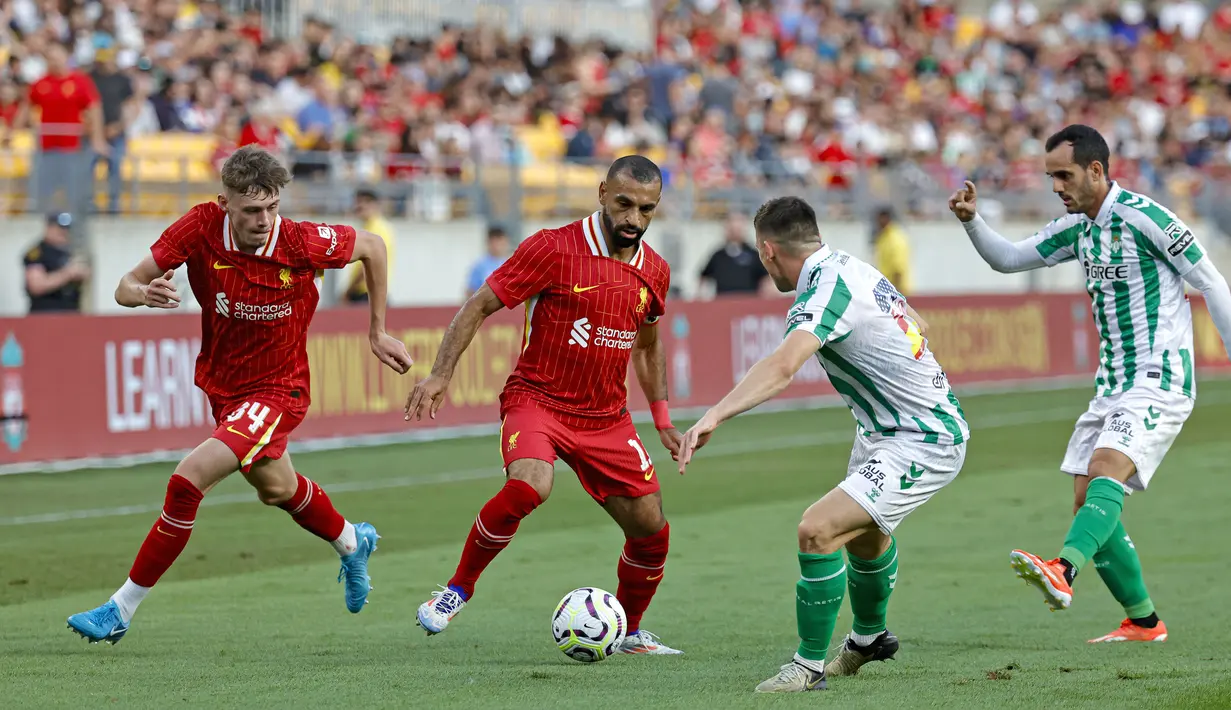 Gol tunggal Dominik Szoboszlai tercipta berkat kerjasama apik dengan Mohamed Salah. Kombinasi keduanya berhasil membobol gawang Betis dan memberikan keunggulan bagi Liverpool hingga laga usai. (AFP/Kamil Krzaczynski)