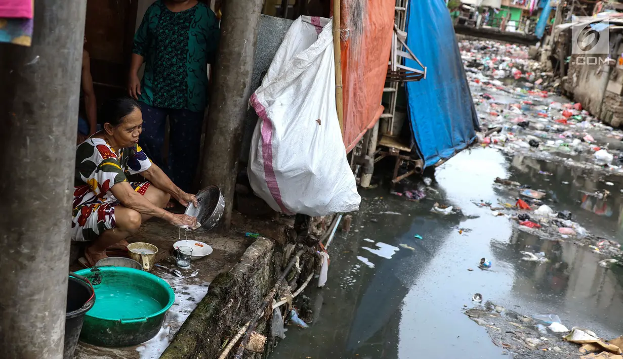 Seorang wanita mencuci piring di pinggir kali di Tanah Abang, Jakarta, Senin (4/9). Tingkat kemiskinan itu didasarkan pada data Badan Pusat Statistik (BPS). (Liputan6.com/Angga Yuniar)