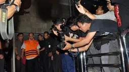 Meninggalkan KPK, Gulat Manurung yang mengenakan baju tahanan berwarna oranye dikawal ketat petugas, Jakarta, (26/9/14). (Liputan6.com/Miftahul Hayat) 