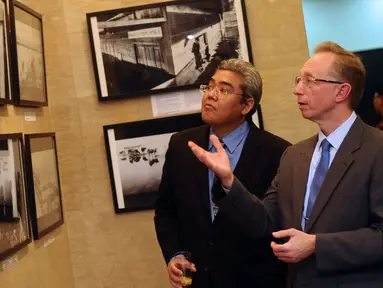 Duta Besar Rusia untuk Indonesia, Mikhail Galuzin (kanan) bersama salah satu pengunjung melihat hasil liputan pewarta foto Rusia, Andrey Stenin di Russian Center for Science and Culture, Jakarta, Selasa (22/12/2015). (Liputan6.com/Helmi Fithriansyah)
