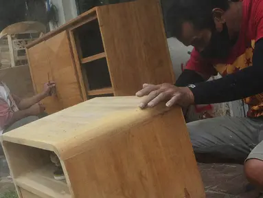 Pekerja menyelesaikan pembuatan furnitur atau perlengkapan rumah berbahan kayu dari Jepara di Ciputat, Tangerang Selatan, Selasa (14/9/2021). Pedagang di tempat tersebut mengakui selama PPKM ini daya beli masyarakat terhadap furnitur meningkat. (Liputan6.com/Johan Tallo)