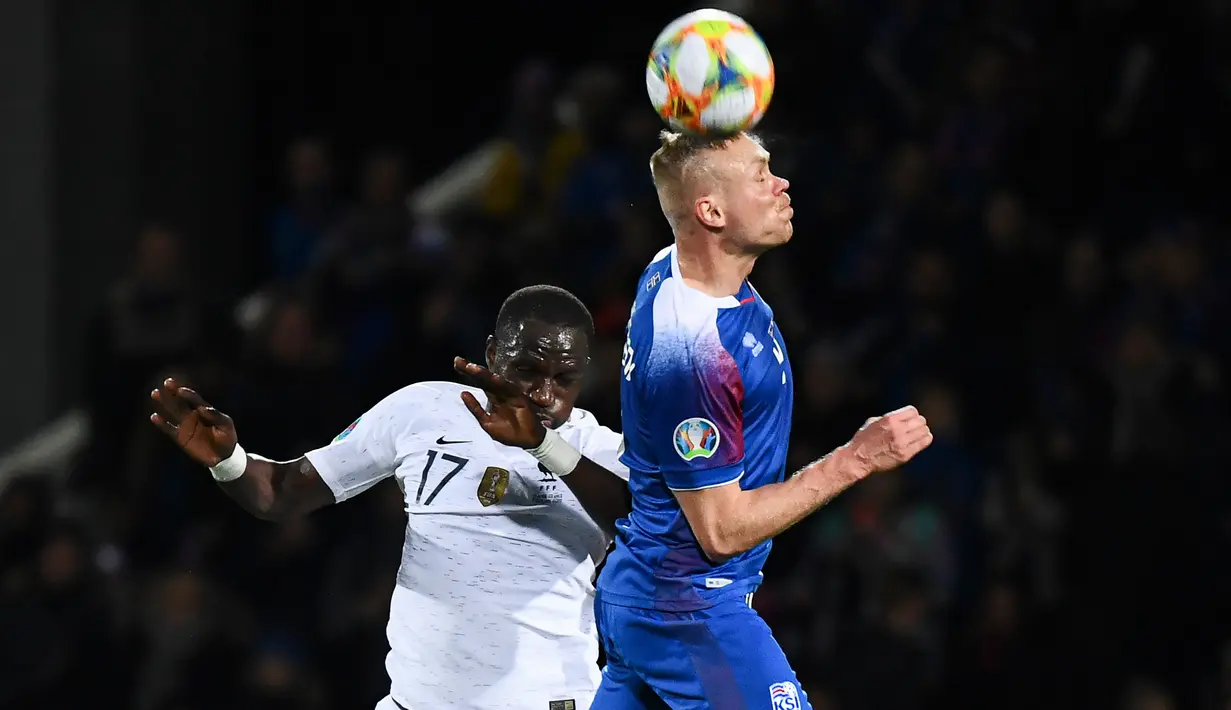 Pemain Islandia, Kolbeinn Sigthorsson berebut bola dengan gelandang Prancis, Moussa Sissoko dalam laga lanjutan Grup H Kualifikasi Piala Eropa 2020. di Stadion Laugardalsvollur, Reykjavik, Jumat (11/10/2019). Timnas Prancis harus susah payah mengalahkan Islandia 1-0. (Jonathan NACKSTRAND/AFP)