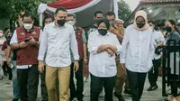 Mensos Risma dan Wali Kota Surabaya Eri Cahyadi saat meninjau pembagian bansos di Surabaya. (Dian Kurniawan/Liputan6.com)