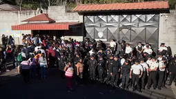 Aparat kepolisian menjaga pintu masuk menyusul kebakaran sebuah asrama penampungan anak-anak di Guatemala, Rabu (8/3). Kebakaran terjadi setelah 60 remaja mengamuk dan membakar kasur karena perlakuan buruk yang mereka terima. (AP Photo/Luis Soto)