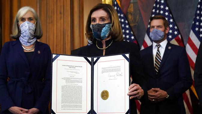 Ketua DPR Nancy Pelosi menampilkan dokumen pemakzulan Presiden Donald Trump yang ditandatanganinya di Capitol Hill, Washington, Amerika Serikat, Rabu (13/1/2021). Jelang akhir kekuasaannya, Donald Trump kembali dimakzulkan oleh DPR AS untuk kedua kalinya. (AP Photo/Alex Brandon)