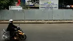 Seorang wanita mengendarai motor melewati depan Pasar Kramatjati yang  mengalami revitalisasi di Jakarta, Jumat (23/10/2015). Pasar Kramatjati mulai direvitalisasi pada Juli lalu dan ditargetkan selesai hingga 18 bulan kedepan. (Liputan6.com/Yoppy renato)