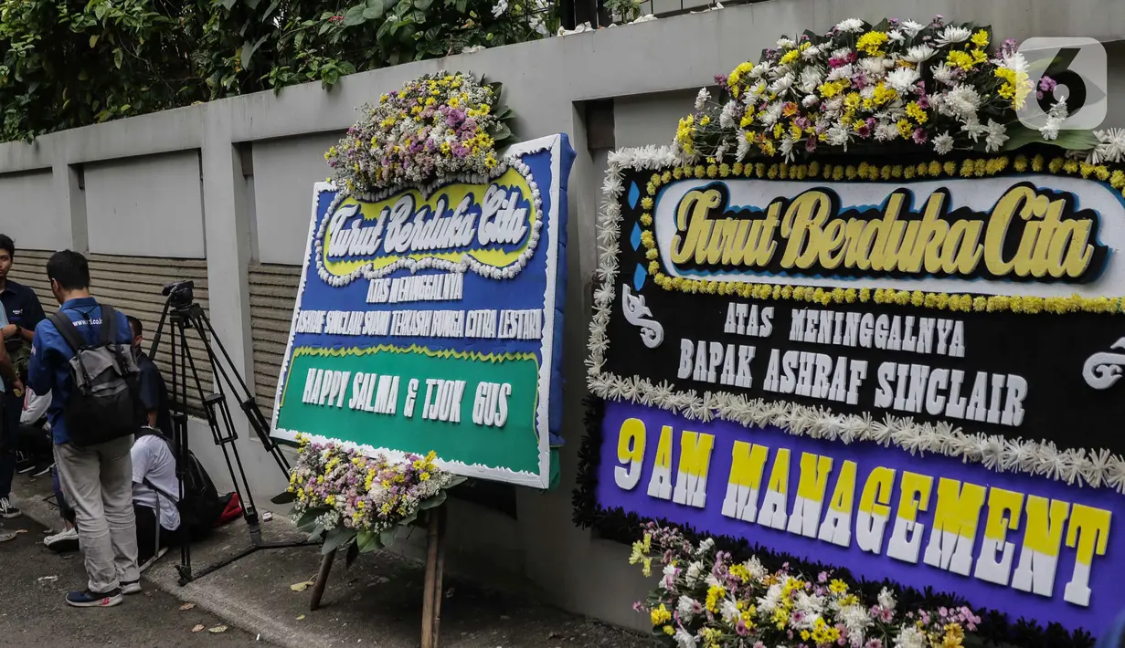 Karangan bunga ucapan duka cita atas meninggalnya almarhum Ashraf Sinclair di kawasan Pejaten Barat IV, Jakarta, Selasa (18/2/2020). Ashraf Sinclair dinyatakan meninggal oleh dokter di Rumah Sakit MMC Kuningan, Jakarta Selatan pukul 04.51 WIB. (Liputan6.com/Faizal Fanani)