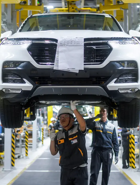 Pekerja mengecek mobil saat perakitan di pabrik VinFast, Haiphong, Vietnam, Jumat (14/6/2019). VinFast rencananya akan mulai dikirim ke konsumen pada 17 Juni 2019. (Manan VATSYAYANA/AFP)
