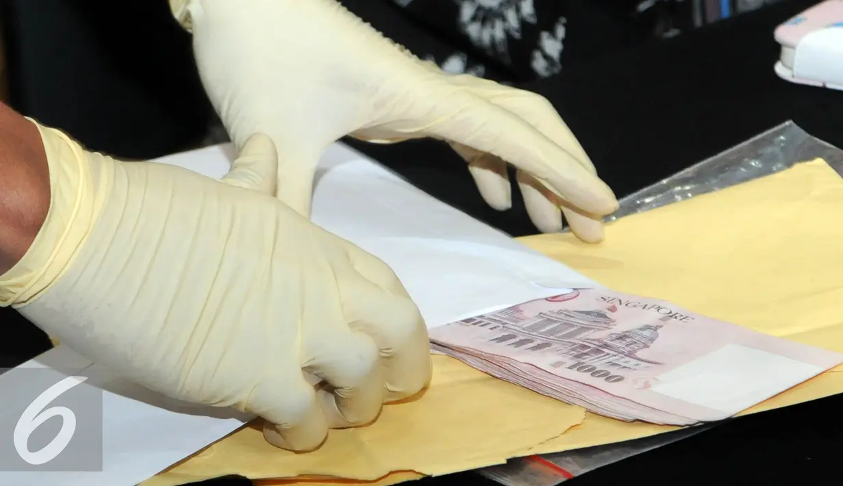 Barang bukti berupa uang dolar Singapura yang berhasil diamankan KPK saat OTT terhadap Panitera Pengganti PN Jakpus, Jakarta, Jumat (1/7). (Liputan6.com/Helmi Afandi)