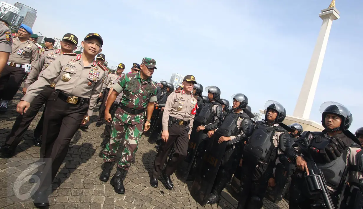 Kapolri Jenderal Tito Karnavian bersama Panglima TNI Jenderal Gatot Nurmantyo meninjau pasukan TNI dan Polri saat apel kesiapsiagaan pengamanan tahap kampanye Pilkada Serentak 2017 di Silang Monas, Jakarta, Rabu (2/11). (Liputan6.com/Immanuel Antonius)