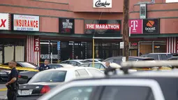 Aparat kepolisian berjaga di luar toko pakaian Marathon Clothing setelah insiden penembakan rapper kenamaan Nipsey Husle di Los Angeles, Minggu (31/3). Rapper yang masuk nominasi Grammy Awards 2019 itu sempat dilarikan ke rumah sakit, tetapi nyawanya tidak bisa diselamatkan. (AP/Damian Dovarganes)
