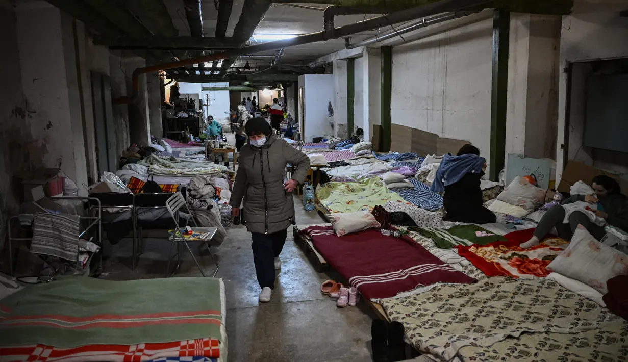 Anak-anak yang dirawat di rumah sakit pediatri ditempatkan tempat tidur mereka di ruang bawah tanah rumah sakit yang digunakan sebagai tempat perlindungan bom di Kiev, Senin (28/2/2022). Tentara Rusia mengatakan, warga sipil Ukraina dapat meninggalkan ibu kota Kiev dengan bebas. (Aris Messinis / AFP