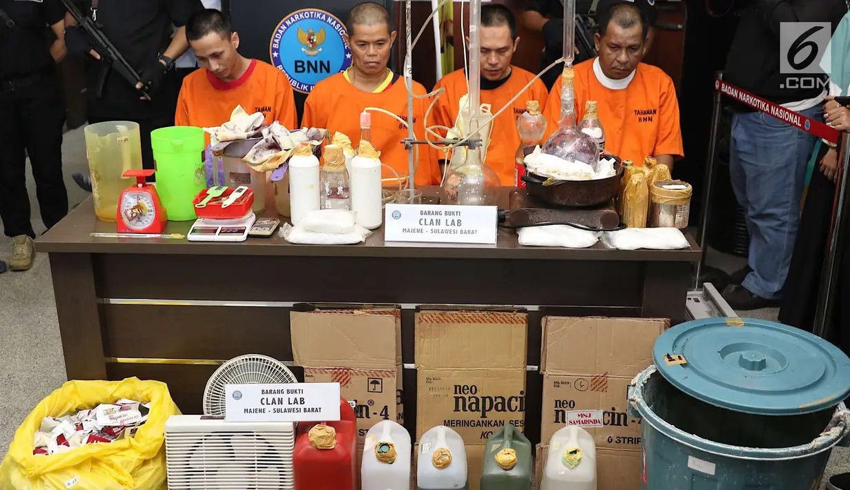 Tersangka dan barang bukti kasus penggerebekan pabrik gelap narkoba di Majene ditunjukkan di Gedung BNN Jakarta, Kamis (9/8). Petugas mengamankan barang bukti berupa narkotika dan bahan pembuatnya. (Liputan6.com/Immanuel Antonius)