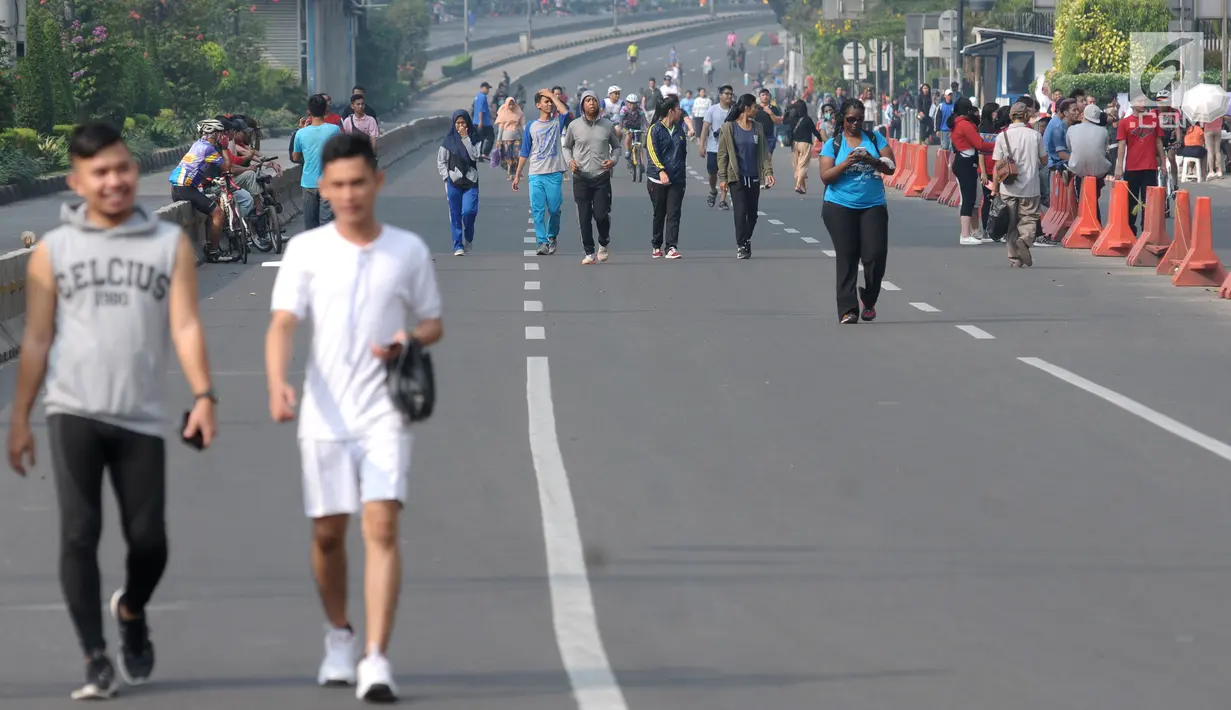 Warga berjalan santai di Jalan Jenderal Sudirman saat pelaksanaan Hari Bebas Kendaraan Bermotor (HBKB), Jakarta, Minggu (3/6). Pemprov DKI Jakarta berencana meniadakan pelaksanaan HBKB pada 10, 17, dan 24 Juni 2018. (Liputan6.com/Helmi Fithriansyah)