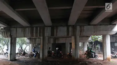 Pengendara motor melintasi jalan setapak di kolong tol di kawasan Lebak Bulus, Jakarta, Selasa (13/2). Untuk menghindari macet sebagian pengendara memanfaatkan jalan setapak tersebut untuk memersingkat waktu tempuh. (Liputan6.com/Immanuel Antonius)