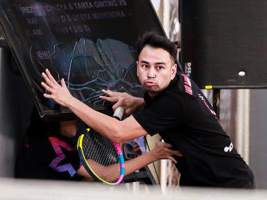 Selebritas Indonesia, Raffi Ahmad menabrak layar TV setelah berusaha mengembalikan bola ke arah pasangan Rezky Aditya dan Tanta Ginting pada laga tenis nomor ganda putra Turnamen Olahraga Selebriti Indonesia di GOR UNJ, Jakarta, Minggu (30/07/2023). Raffi yang berpasangan dengan Deddy Mahendra Desta menang dengan skor 4-6, 6-4, dan 6-4. (Bola.com/Bagaskara Lazuardi)