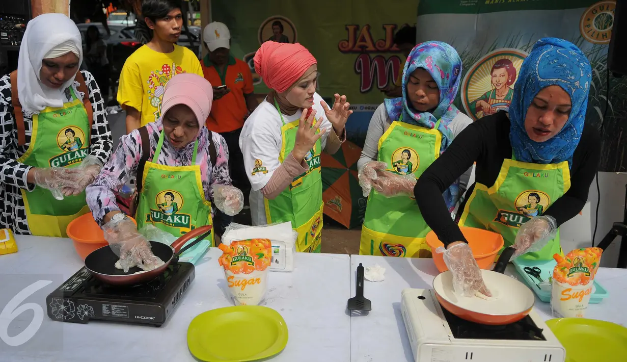 Juru masak sedang mendemonstrasikan membuat jajanan tradisional di Pasar Pondok Labu, Jakarta Selatan (10/09). Kegiatan bersama ibu-ibu PKK sebagai bentuk kepedulian terhadap pelestarian makanan tradisonal. (Liputan6.com/Gempur M Surya). 