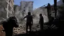Serangan udara Israel terus menyasar wilayah Lebanon selatan dan pinggiran selatan Beirut, termasuk Jnah. Tampak dalam foto, orang-orang berkumpul saat sebuah ekskavator membersihkan puing-puing di lokasi serangan Israel pada Minggu 5 April 2026 terhadap sebuah bangunan di lingkungan Jnah, Beirut, Lebanon, Senin 6 April 2026. (AP Photo/Hassan Ammar)
