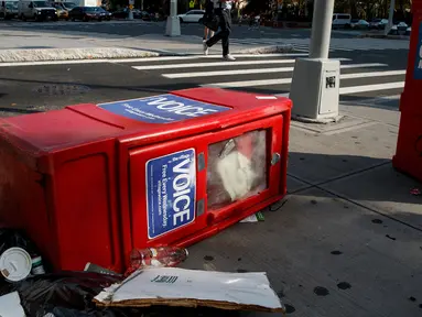Sebuah kotak surat kabar Village Voice tergeletak di samping tempat sampah di Manhattan, AS (22/8). Village Voice  adalah surat kabar mingguan tertua dan paling terkenal di AS. (Drew Angerer/Getty Images/AFP)