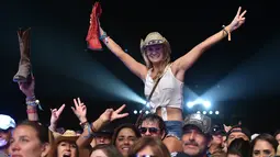 Seorang pengunjung wanita tersenyum saat berjoged menggunakan topi koboi saat menghadiri Festival musik Country Stagecoach di Empire Polo Club di Indio, California, 29 April 2016. (AFP PHOTO/Kevin Winter)