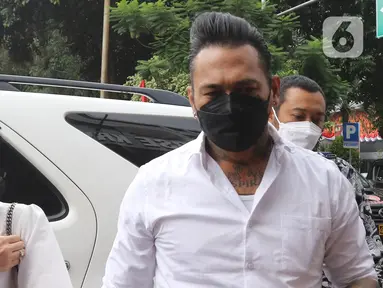 Musikus I Gede Ary Astina alias Jerinx didampingi istrinya, Nora Alexandra, tiba di Polda Metro Jaya, Jakarta, Sabtu (14/08/2021). Kedatangan Jerinx untuk menghadiri proses mediasi dengan pegiat media sosial Adam Deni terkait kasus dugaan pengancaman yang menjeratnya. (Liputan6.com/Herman Zakharia)