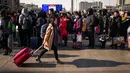 Penumpang mengantre di stasiun kereta api untuk pulang ke kampung halaman mereka, Beijing, China (23/1). Tradisi mudik atau pulang kampung (Chunyun) ini sudah menjadi tradisi tahunan yang turun temurun bagi orang tionghoa. (AFP/Nicolas Asfouri)
