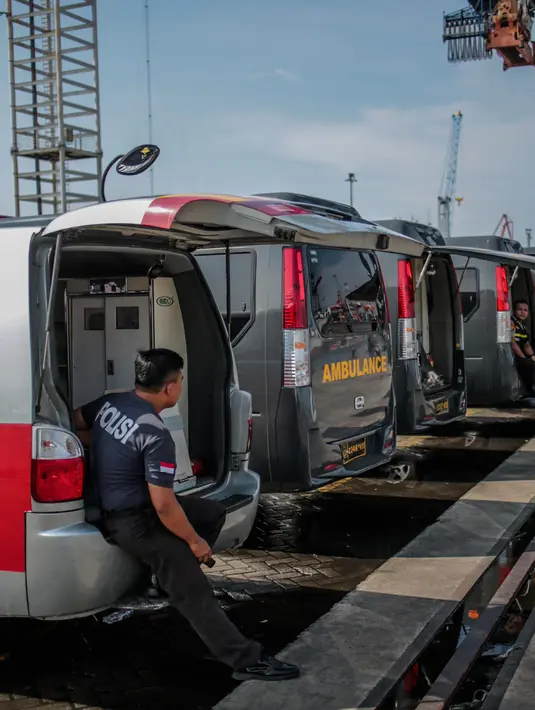 Petugas kepolisian bersiaga di ambulans yang disiapkan di Posko Evakuasi, Tanjung Priok, Jakarta, Senin (29/10). Posko itu menjadi tempat transit korban jatuhnya pesawat Lion Air JT610 di laut utara Karawang, Jawa Barat. (Liputan6.com/Faizal Fanani)