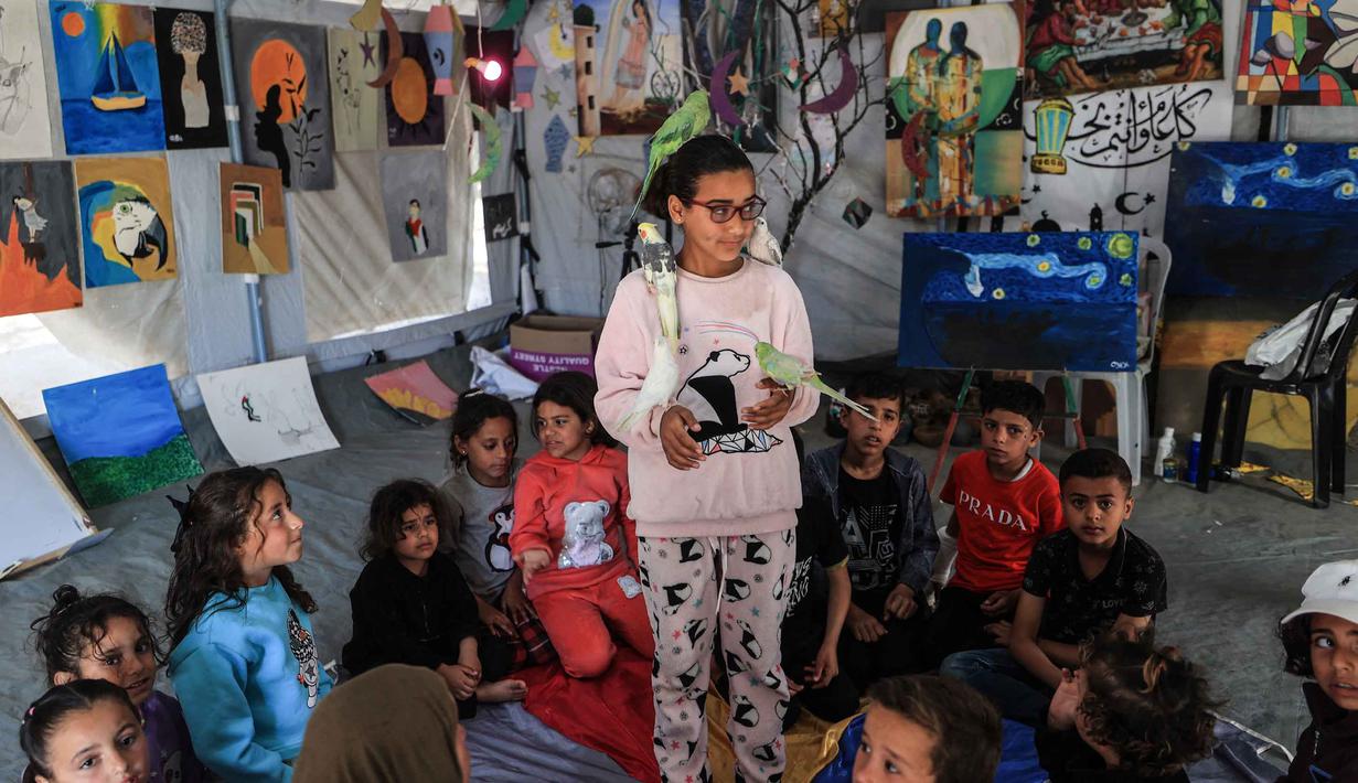 Sekitar 61 persen menderita gangguan stres pasca-trauma (PTSD), 38 persen menderita depresi, dan 41 persen menderita kecemasan. Tampak dalam foto, anak-anak pengungsi Palestina mengikuti sesi konseling psikologis di sebuah studio seni yang menggunakan hewan peliharaan dan burung di daerah Al-Zawaida, Jalur Gaza Tengah, pada Selasa 21 April 2026. (Eyad Baba/AFP)
