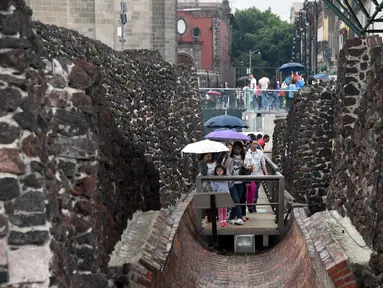 Pengunjung berjalan di Templo Mayor di kota Meksiko, (12/8). Templo Mayor merupakan bagian dari pusat sejarah kota Meksiko, yang dimasukan ke Daftar Warisan Dunia UNESCO pada tahun 1987. (AFP Photo/Rodrigo Arangua)