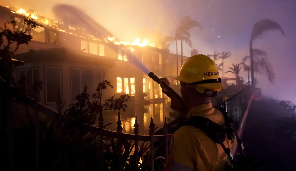 Seorang petugas pemadam kebakaran bekerja untuk memadamkan sebuah bangunan yang terbakar saat kebakaran hutan di Laguna Niguel, California, Amerika Serikat, 11 Mei 2022. (AP Photo/Marcio J. Sanchez)