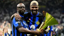 Pemain Inter Milan, Marcus Thuram, merayakan gelar juara Serie A bersama sang ayah yang juga seorang legenda Juventus di Stadion Giuseppe Meazza, (19/5/2024). (AFP/Marco Bertorello)