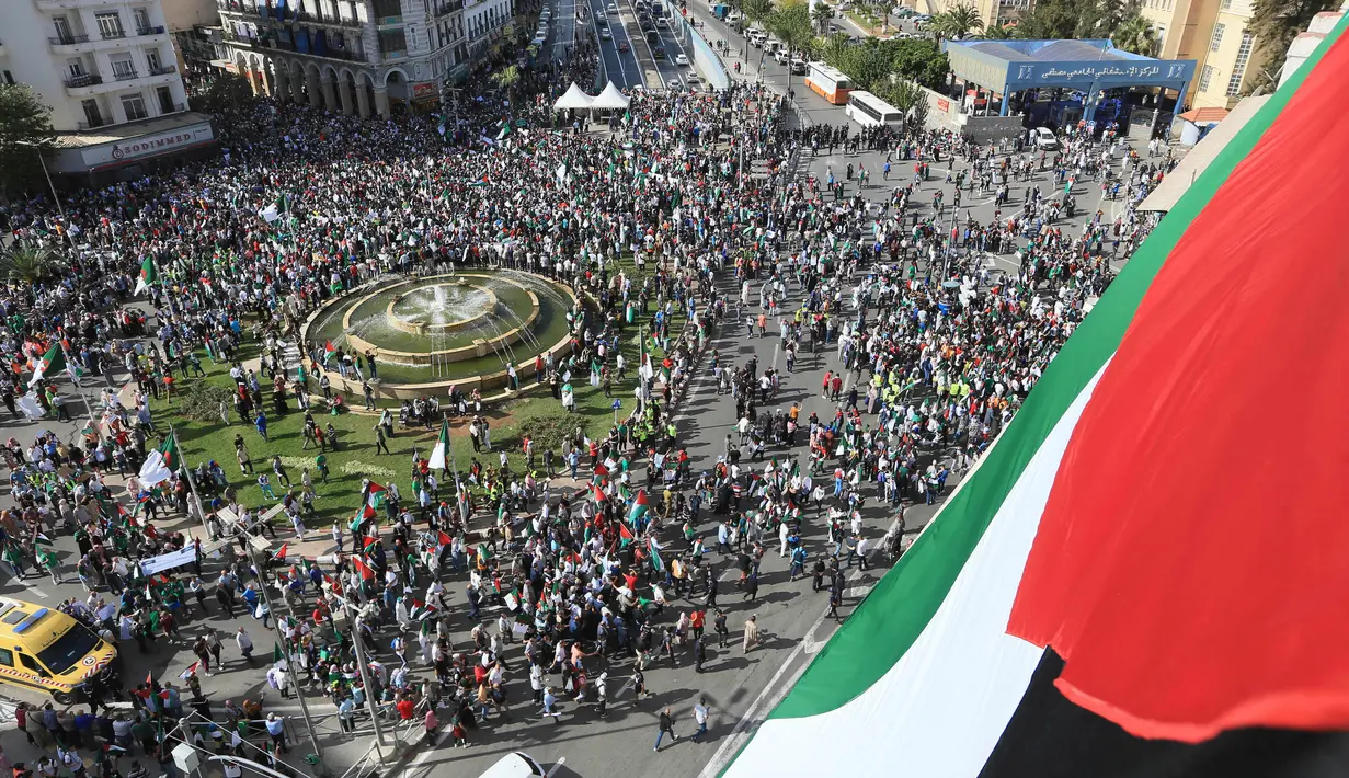 Selama aksi unjuk rasa, para warga Aljazair mengibar-ngibarkan bendera Palestina. (AP Photo/Hassene Dridi)