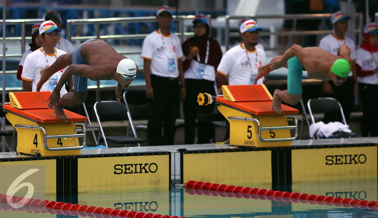 Perenang Jawa Barat, Triadi Fauzi S (tengah) merayakan kemenangan usai berlomba di kelas 100m gaya bebas putra di Gelanggang Renang FPOK UPI, Bandung, Senin (19/9). Triadi berhasil meraih emas dengan 50,49 dtk. (Liputan6.com/Helmi Fithriansyah)
