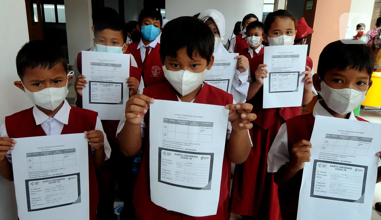 Para siswa menunjukkan Kartu Vaksinasi COVID-19 usai mengikuti vaksinasi di SDN 02 Ciater, Tangerang Selatan, Selasa (14/12/2021). Mulai Hari ini, 11 provinsi di Indonesia secara serentak melaksanakan vaksinasi COVID-19 dengan sasaran anak berusia 6 hingga 11 tahun. (merdeka.com/Arie Basuki)