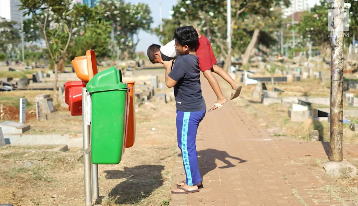 Anak-anak bermain di sekitar Taman Pemakaman Umum (TPU) Karet Bivak, Jakarta, Selasa (10/9/2019). Keterbatasan ruang terbuka hijau memaksa sebagian anak-anak di Ibu Kota bermain tidak pada tempatnya, meskipun dalam kondisi yang tidak layak. (Liputan6.com/Immanuel Antonius)