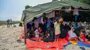 Seratusan pengungsi Rohingya kembali berlabuh Aceh. Hingga Minggu pagi, para pengungsi  ini masih berkumpul di pinggir pantai, setelah turun dari sebuah kapal kayu. (CHAIDEER MAHYUDDIN/AFP)
