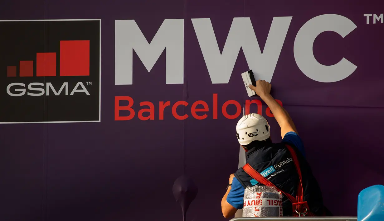 Pekerja memperbaiki poster yang mengumumkan Mobile World Congress (MWC) 2020 di lokasi pameran di Barcelona, Spanyol, Selasa (11/2/2020). Total kerugian akibat dibatalkannya MWC 2020 diperkirakan mencapai Rp 7,3 triliun). (AP Photo/Emilio Morenatti)