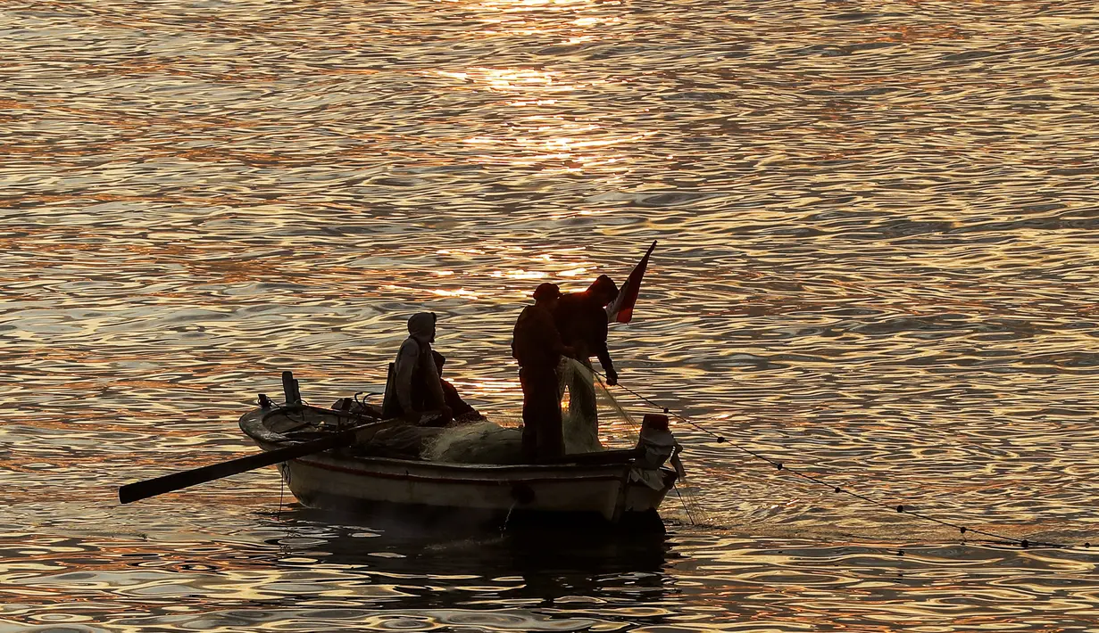 Nelayan melemparkan jala dari perahu saat matahari terbenam ke laut Mediterania di daerah Dbayeh, utara ibukota Beirut (5/12/2019). Laut Tengah, kadangkala disebut Laut Mediterania adalah laut antarbenua yang terletak antara Eropa di utara, Afrika di selatan dan Asia di timur. (AFP/Josep Eid)