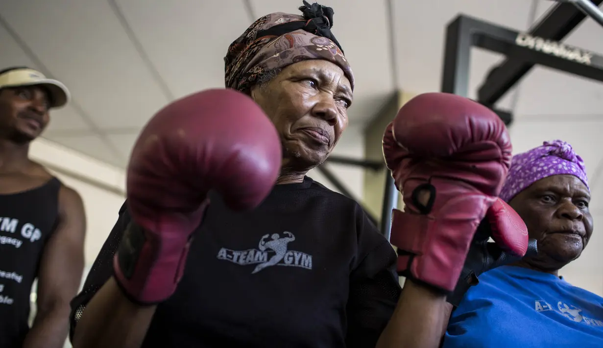 Para nenek berlatih tinju pada Boxing Gogos di Cosmo City, Johannesburg, Selasa (19/9/2017). Berkat latihan rutin yang dipimpin Claude Maphosa ini para lansia berhasil sembuh dari penyakit dan hidup lebih sehat. (AFP/Gulshan Khan) 