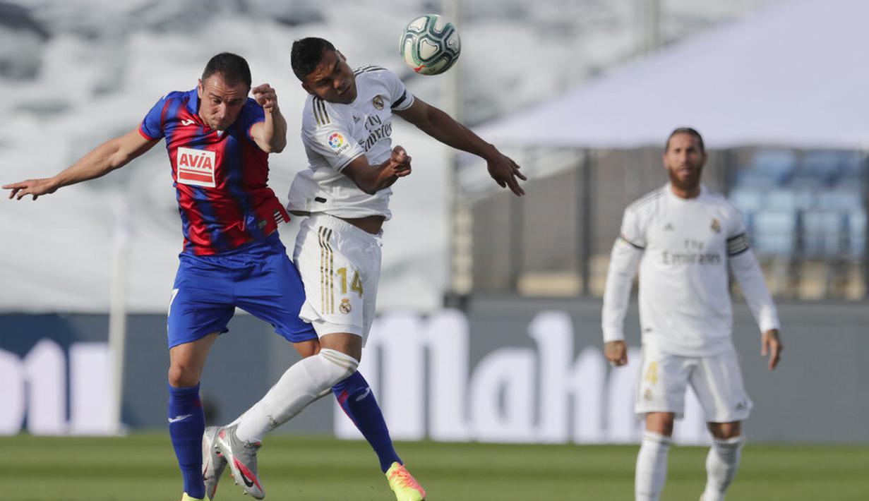 Gelandang Real Madrid, Casemiro, duel udara dengan pemain Eibar, Kike Garcia, pada laga La Liga di Estadio Alfredo Di Stefano, Senin (15/6/2020). Real Madrid menang 3-1 atas Eibar. (AP/Bernat Armangue)