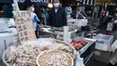 Vendor menjual makanan laut segar dan kering di area "pasar ikan luar" Tsukiji di Tokyo pada 28 Desember 2022. Menjelang liburan Tahun Bar, turis asing dan penduduk lokal berkunjung  ke pasar itu untuk menikmati hidangan bermacam makanan laut. (AFP/Richard A. Brooks)