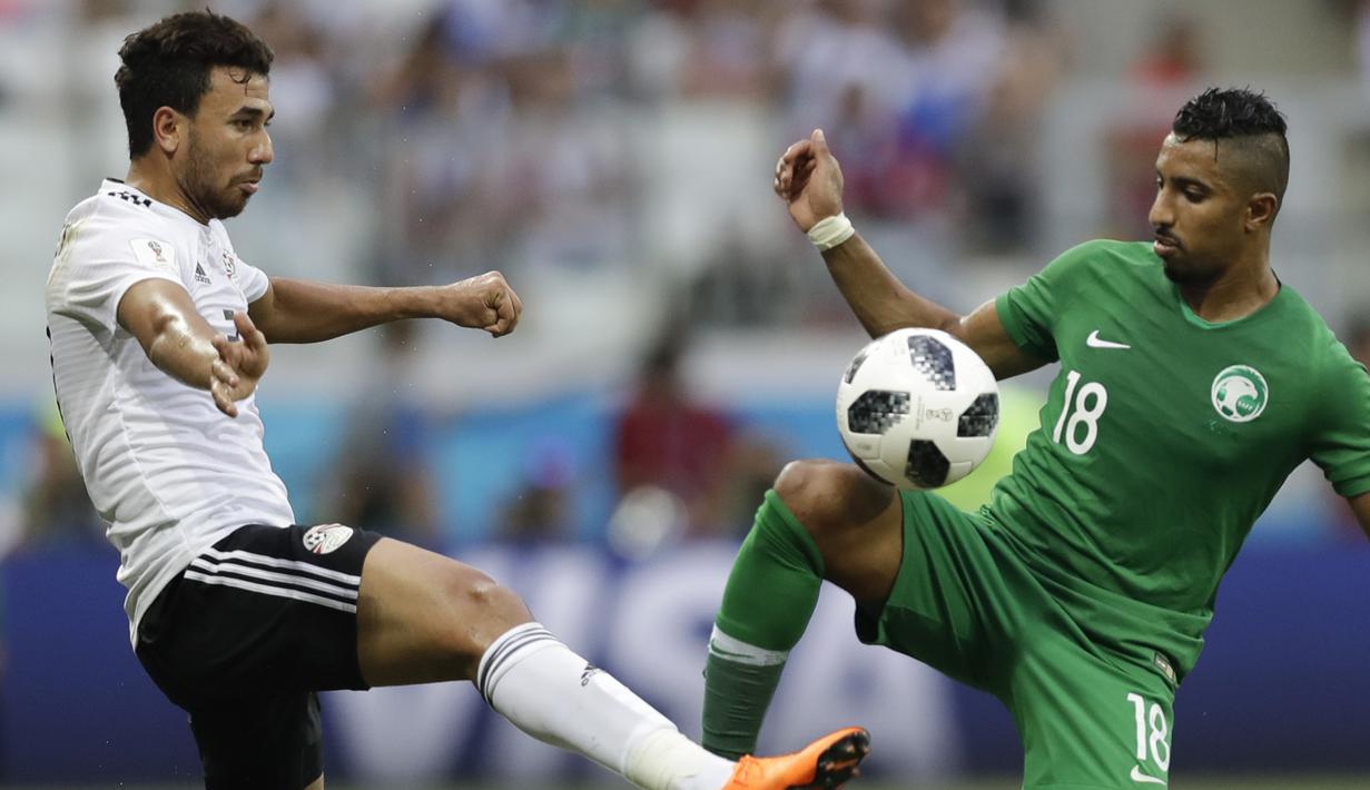 Gelandang Mesir, Trezeguet, berebut bola dengan gelandang Arab Saudi, Salem Al-Dawsari, pada laga grup A Piala Dunia di Volgograd Arena, Volgograd, Senin (25/6/2018). Arab Saudi menang 2-1 atas Mesir. (AP/Andrew Medichini)