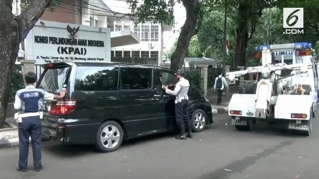 Sebuah taksi diderek petugas karena parkir sembarangan. Saat diderek, sang sopir masih tertidur di dalam mobil.