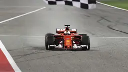Pebalap Ferrari, Sebastian Vettel saat melintasi garis finish balapan F1 GP Bahrain di Sirkuit Sakhir, Manama, Minggu (16/4/2017).  (AFP/POOL/Andrej Isakovic)
