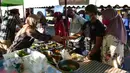 Orang-orang mengenakan masker saat membeli makanan di pasar menjelang berbuka puasa selama bulan suci Ramadan di Provinsi Narathiwat, Thailand, Selasa (5/5/2020). Ramadan kali ini berlangsung di tengah bayang-bayang virus corona COVID-19. (Madaree TOHLALA/AFP)
