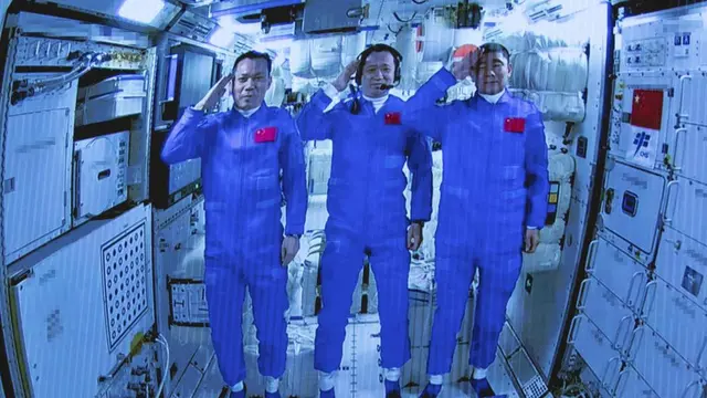 Tiga Astronaut China, berpose dan memberi hormat setelah berhasil memasuki modul Stasiun Luar Angkasa Tianhe pada Kamis (17/6/2021). (Photo credit: Jin Liwang/Xinhua via AP)