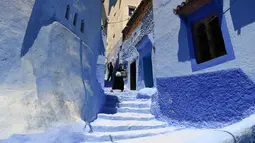 Seorang wanita berjalan di sepanjang gang kecil, Kota Chefchaouen, Maroko, Minggu (1/5). Keindahan kota Chefchaouen bahkan mengalahkan keindahan kota penuh cinta, Paris. (FADEL SENNA / AFP)