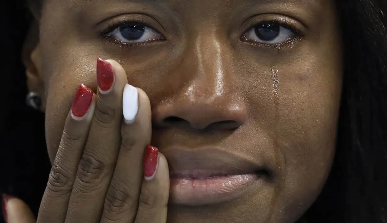 Perenang Amerika Serikat, Simone Manuel, menangis saat akan menerima medali emas usai memenangi nomor 100 m gaya bebas pada Olimpiade 2016 di Rio de Janeiro, Brasil, Jumat (12/8/2016). (AP/Michael Sohn)